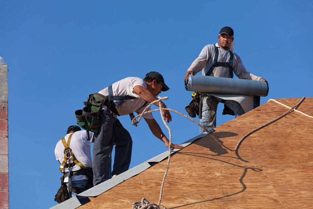 A man holding rolled asphalt roofing