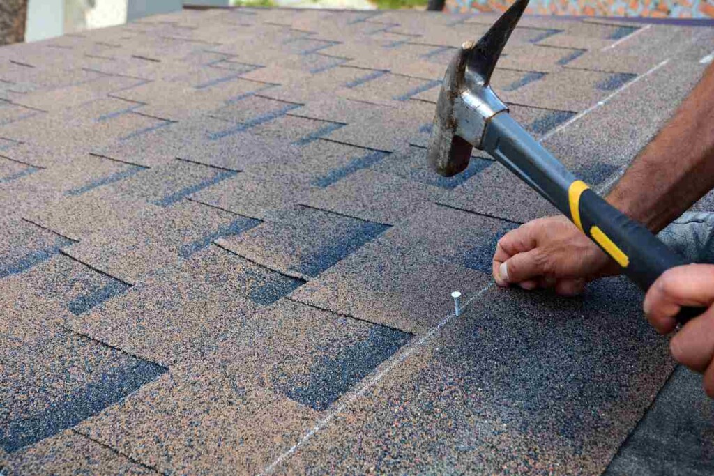 Shingles being nailed into a roof