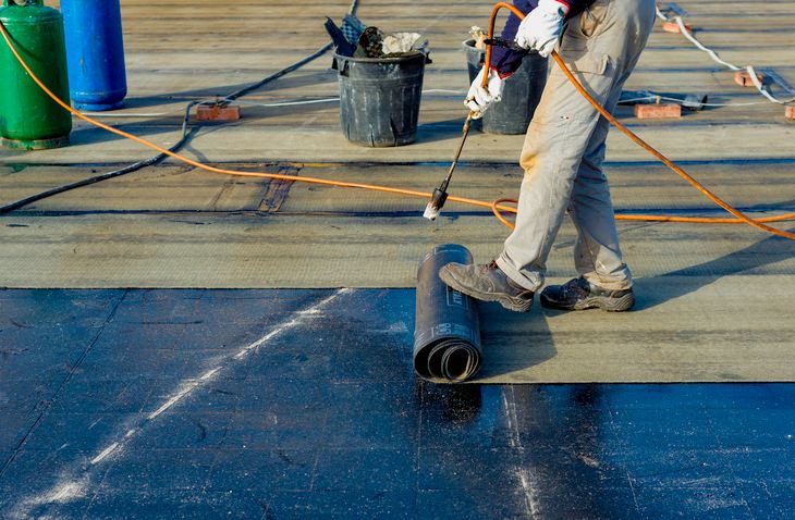 Roofer putting in a cap sheet